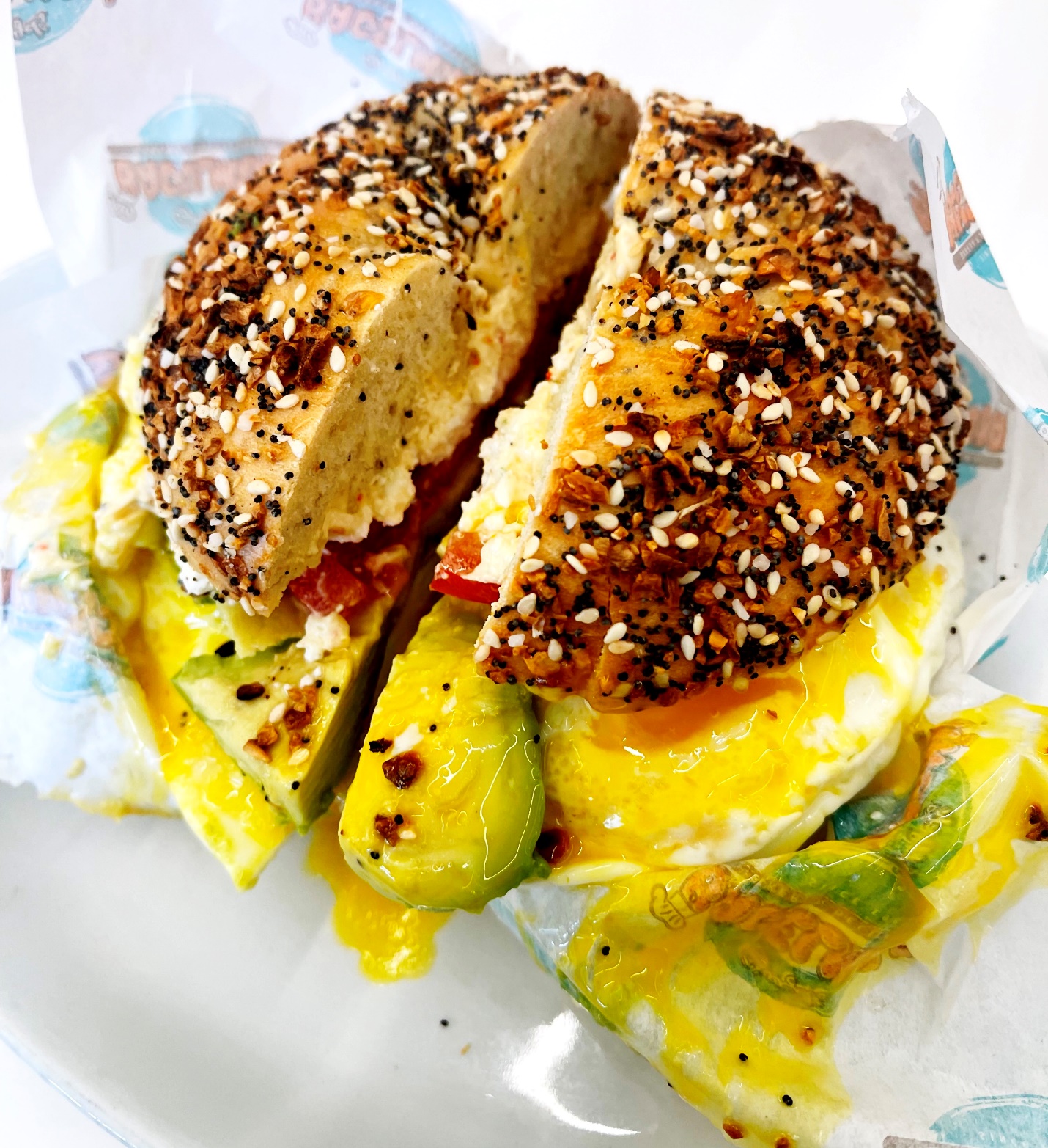 A bagel sandwich with eggs and avocado Description automatically generated with medium confidence