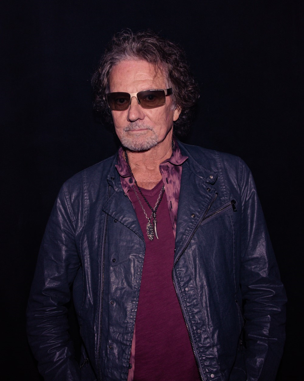 A person wearing sunglasses and a leather jacket Description automatically generated