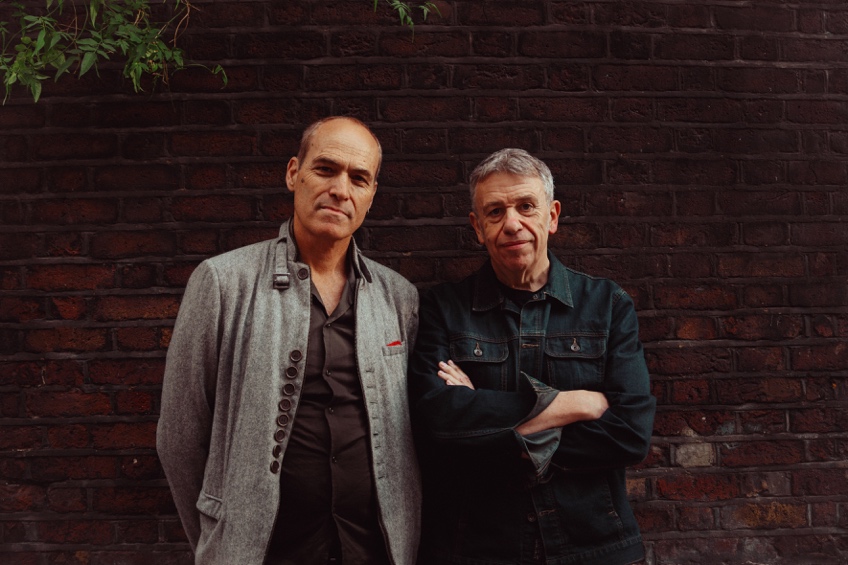 A couple of men standing next to a brick wall

AI-generated content may be incorrect.