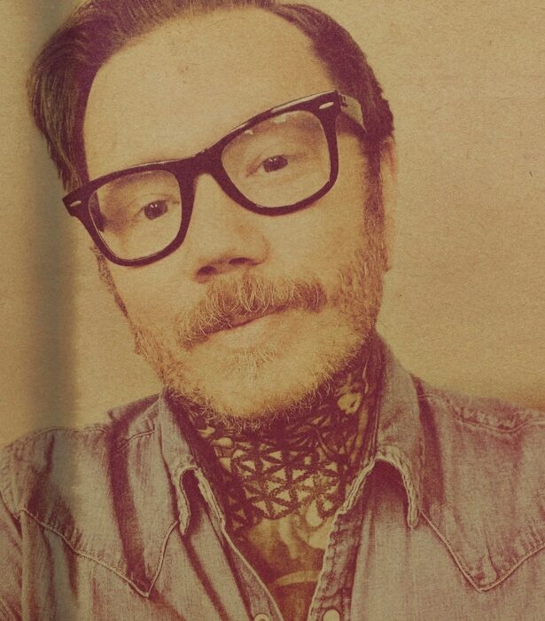 A person with glasses and a mustache Description automatically generated