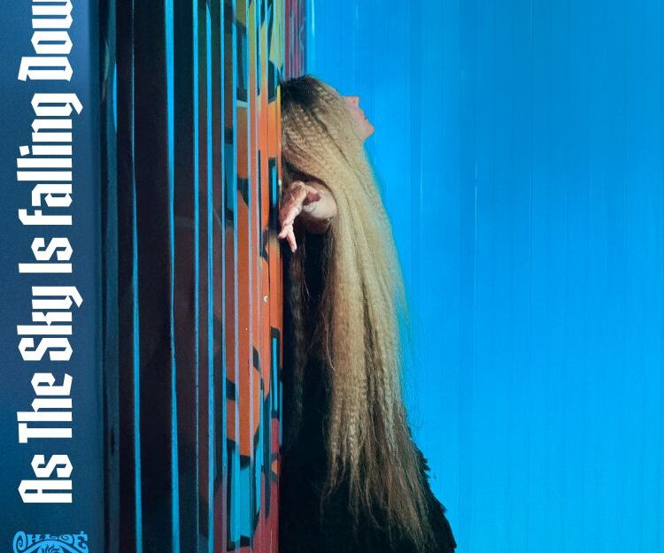 A person with long blonde hair leaning against a wall AI-generated content may be incorrect.
